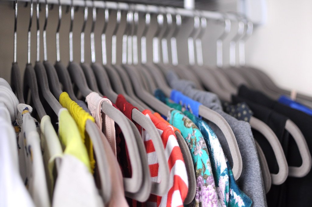 Neatly organized closet with hanging clothes and labeled bins